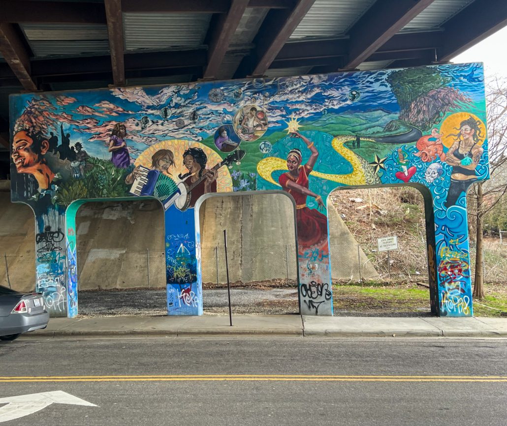 A mural of women of color playing music and dancing. Asheville Vacation Rental