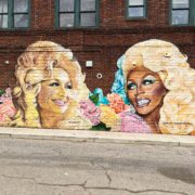 A mural of Dolly Parton on a brick wall.
